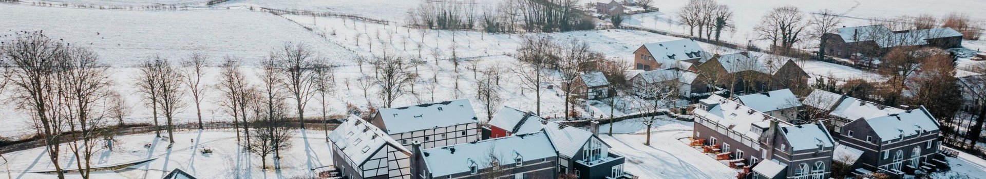 Luchtfoto van vakantiepark De Mechelerhof in Mechelen, Zuid-Limburg, bedekt met sneeuw